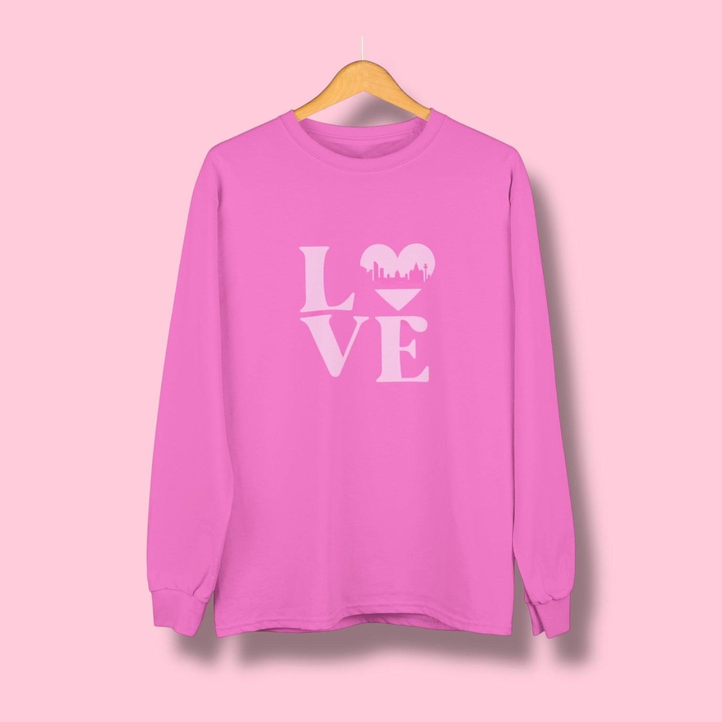 A pale pink Liverpool Love sweatshirt featuring the word LOVE, with a heart-shaped Liverpool skyline design – the perfect Liverpool gift or souvenir.